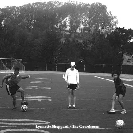 Women's soccer Coach Cunningham lead players Matesha Cheatham (left) and Monica D'Amario (right) in practice drills. LYNNETTE SHEPPARD / GUARDSMAN