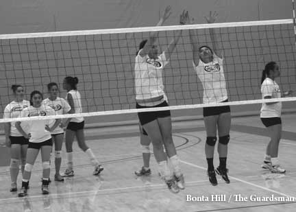 City College Rams volleyball team warm-up before practice with players performing net drills.