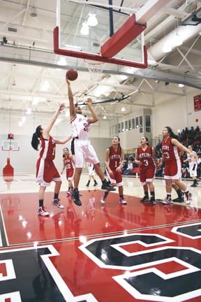 Sophomore forward Cierra Foster (center) goes for a layup over Skyline guard Tina Shiheiber (left), Feb. 19 at the Wellness Center. JESSICA LUTHI / THE GUARDSMAN