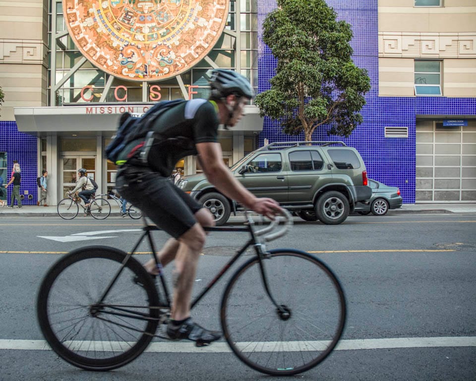 A cyclist rides past the City College Mission Center, Thursday, Sept. 25. (Photo by Niko Plagakis)
