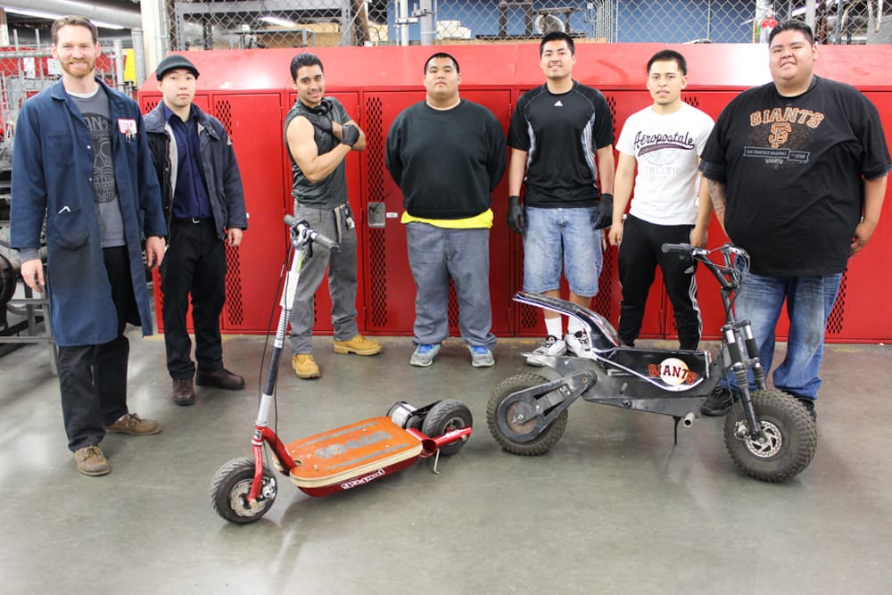 (L-R) City College Automotive Instructor Nick Rothman and his students Andy Chen, Carlos Hernandez, Stephen Orquiza, Jaime Garcia, Jesus Jimenez and Adrian Gomez pose next to the scooter ridden by San Francisco Giants’ mascot. Left is an older scooter that needed repairs on April 2014 at the Evans Center. (All photos by Morgan Henry)