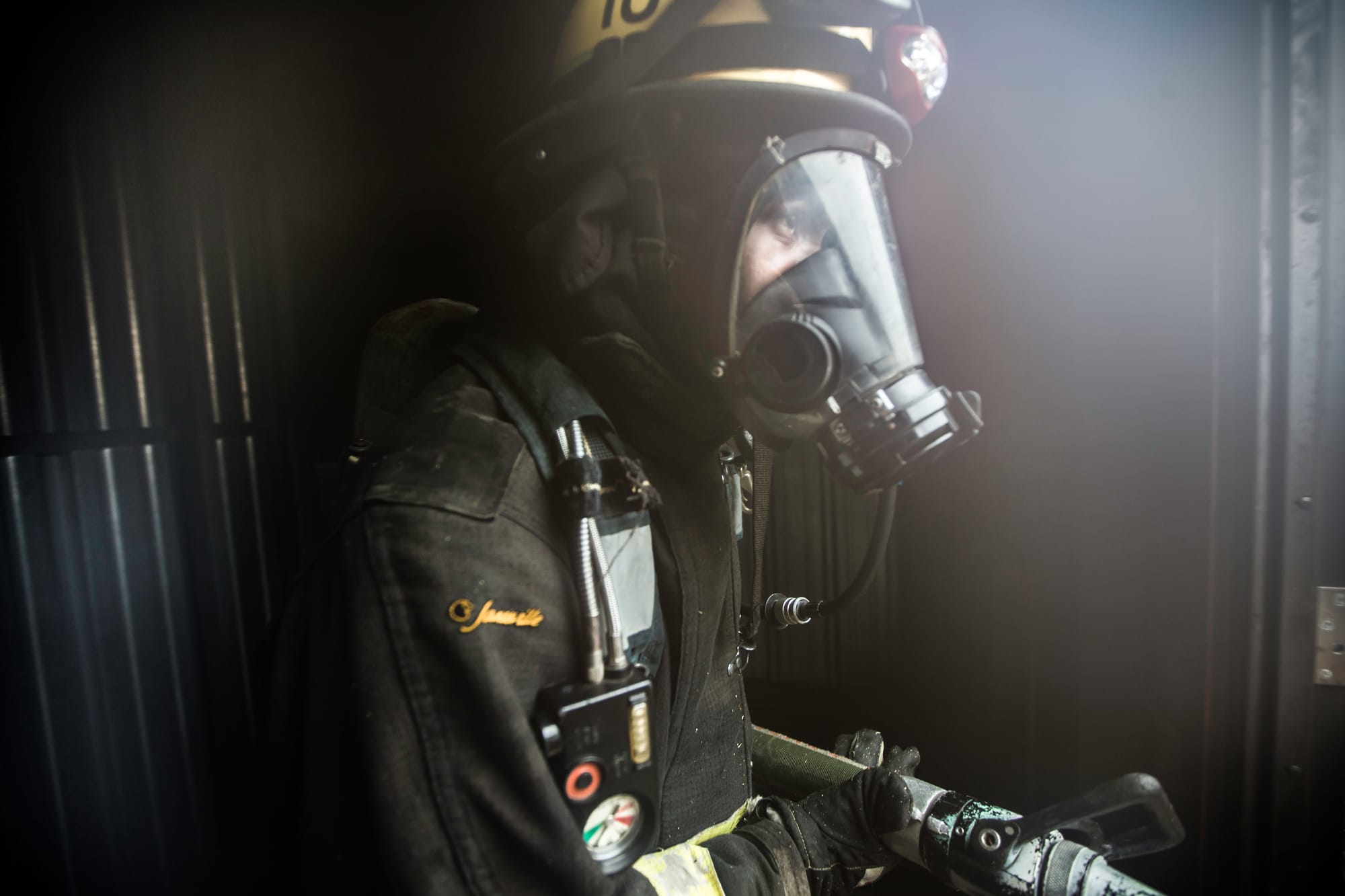 A fire cadet uses the self contained breathing apparatus during hose drills at the live fire traingin that cumulated the 18 weeks of preparation for 29 fire cadets of City College’s Class 15 Fire Fighter One Academy at South San Francisco Fire Department Station 61 on Saturday, May 16 2015. (Photo by Nathaniel Y. Downes/The Guardsman)