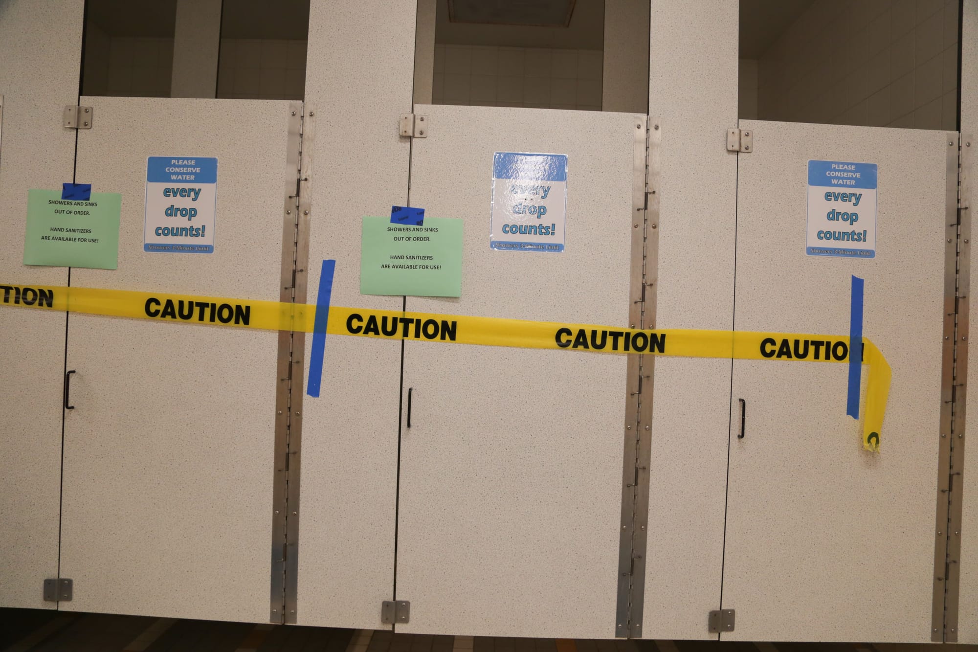 Caution tape marks off Wellness Center bathroom stalls after a leak was caught in a room adjacent to the water system on april 11, 2016. (Photo by Gabriella Angotti Jones/The Guardsman)