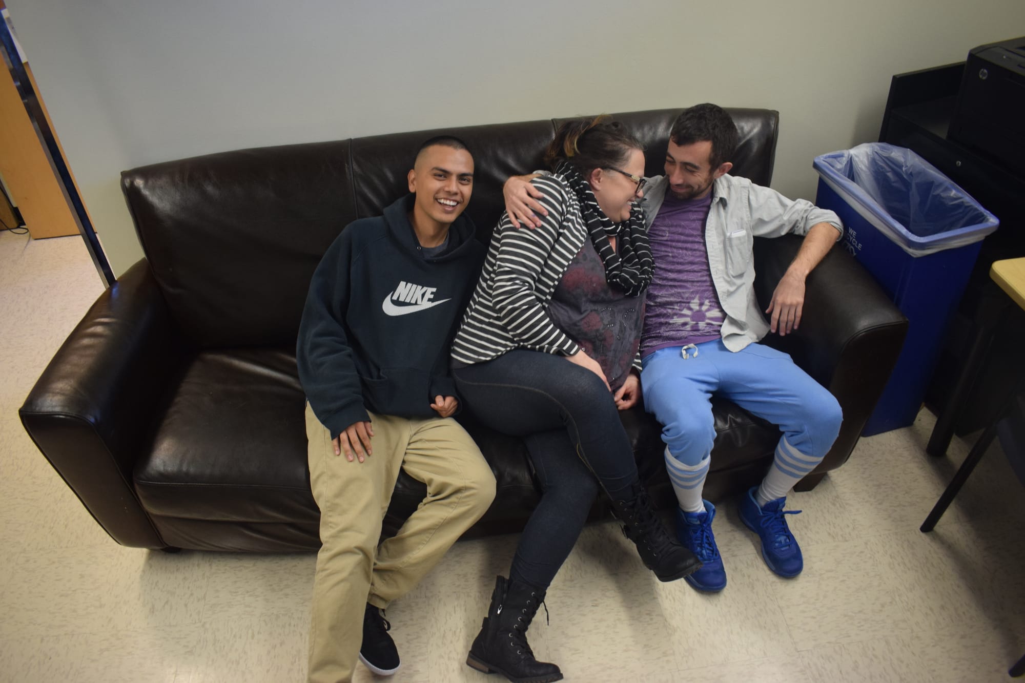 HARTS student worker Juan Duran, Harts Coordinator Maraea Nauta Master and visiting CCSF student Max Cohan pose the couch within the Harts Office. Photo by Sarah Berjan. 