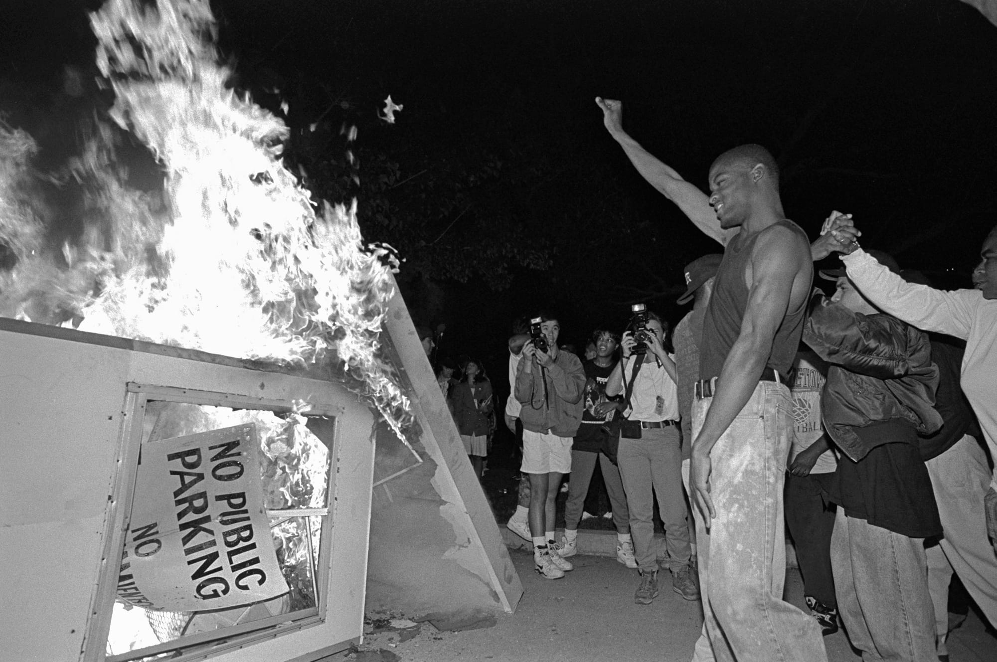 Rioters near Parker Center, LAPD headquarters in downtown Los Angeles, over turn a parking kiosk and set it ablaze. Los Angeles has undergone several days of rioting due to the acquittal of the LAPD officers who beat Rodney King. Hundreds of businesses were burned to the ground and over 55 people have been killed. (Photo by Ted Soqui/Corbis via Getty Images)