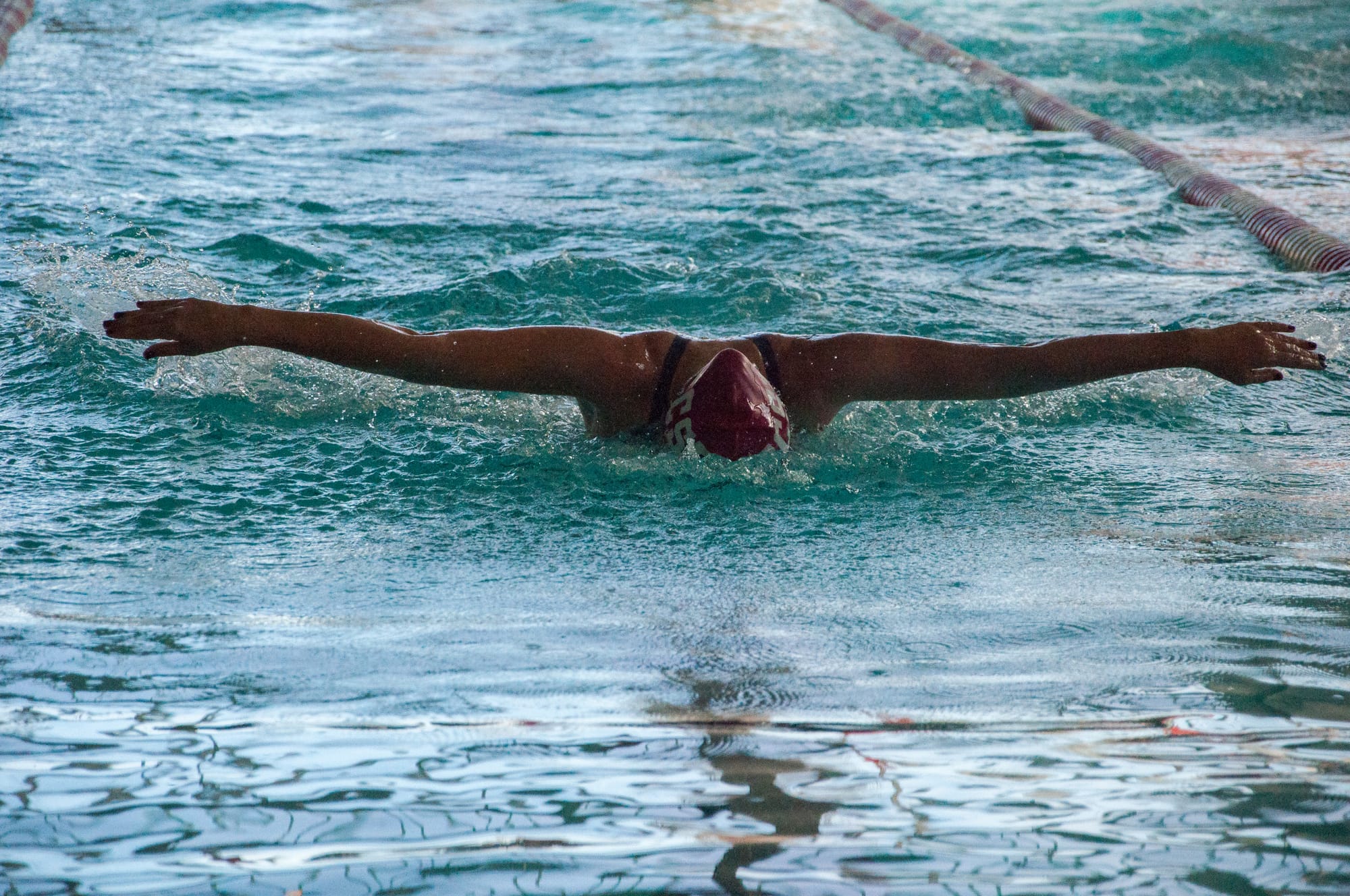 City College women's swimmer Volha Kozel glides with powerful strokes into 1st place in the Women's 100 yard butterfly on Feb. 2, 2018. Photo by Peter J. Suter/The Guardsman. 