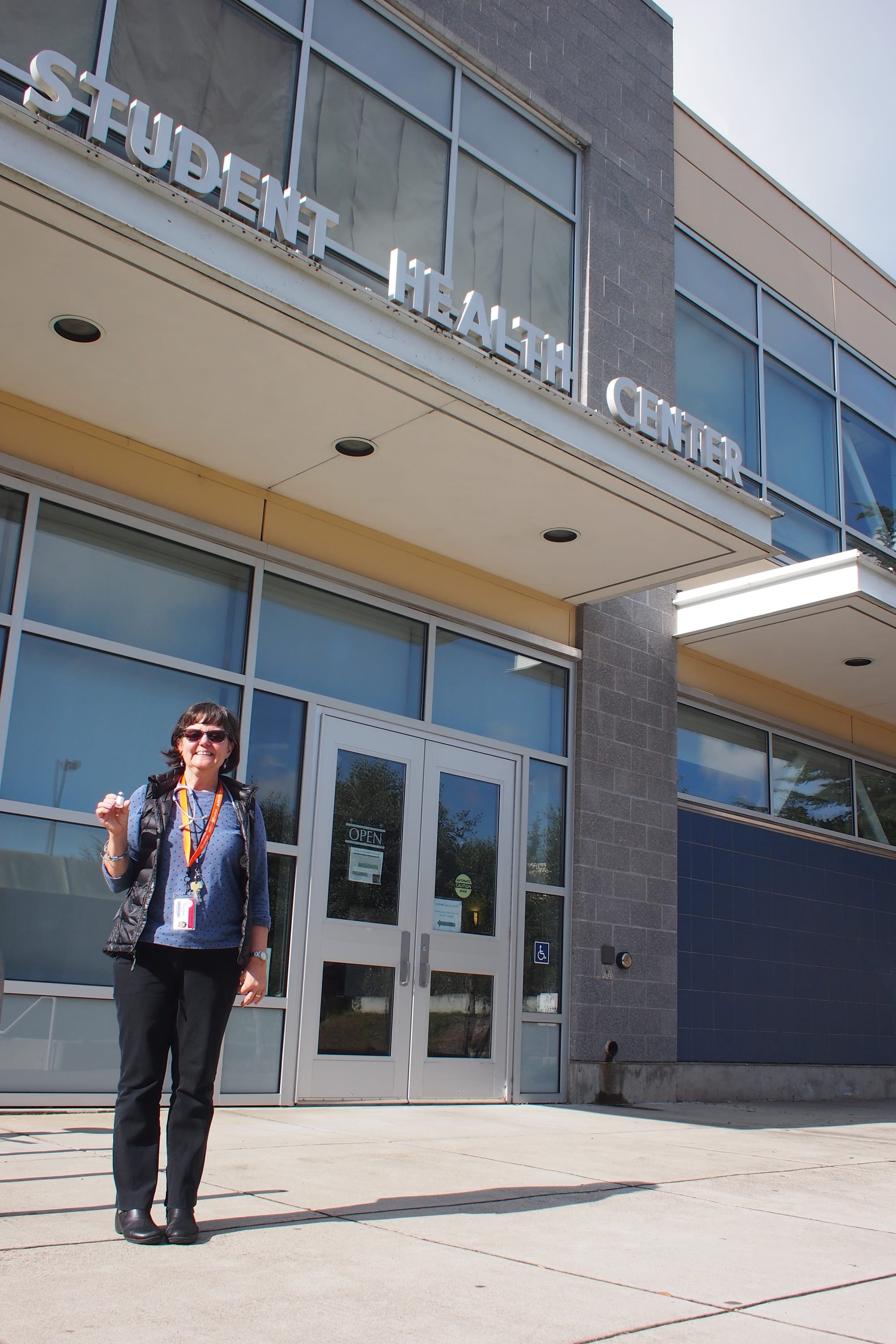 Nurse Paula Cahill standing in front of Student Health Services with a vial of the influenza vaccine on Jan. 24, 2018. Photo by Cameron Ehring/The Guardsman 