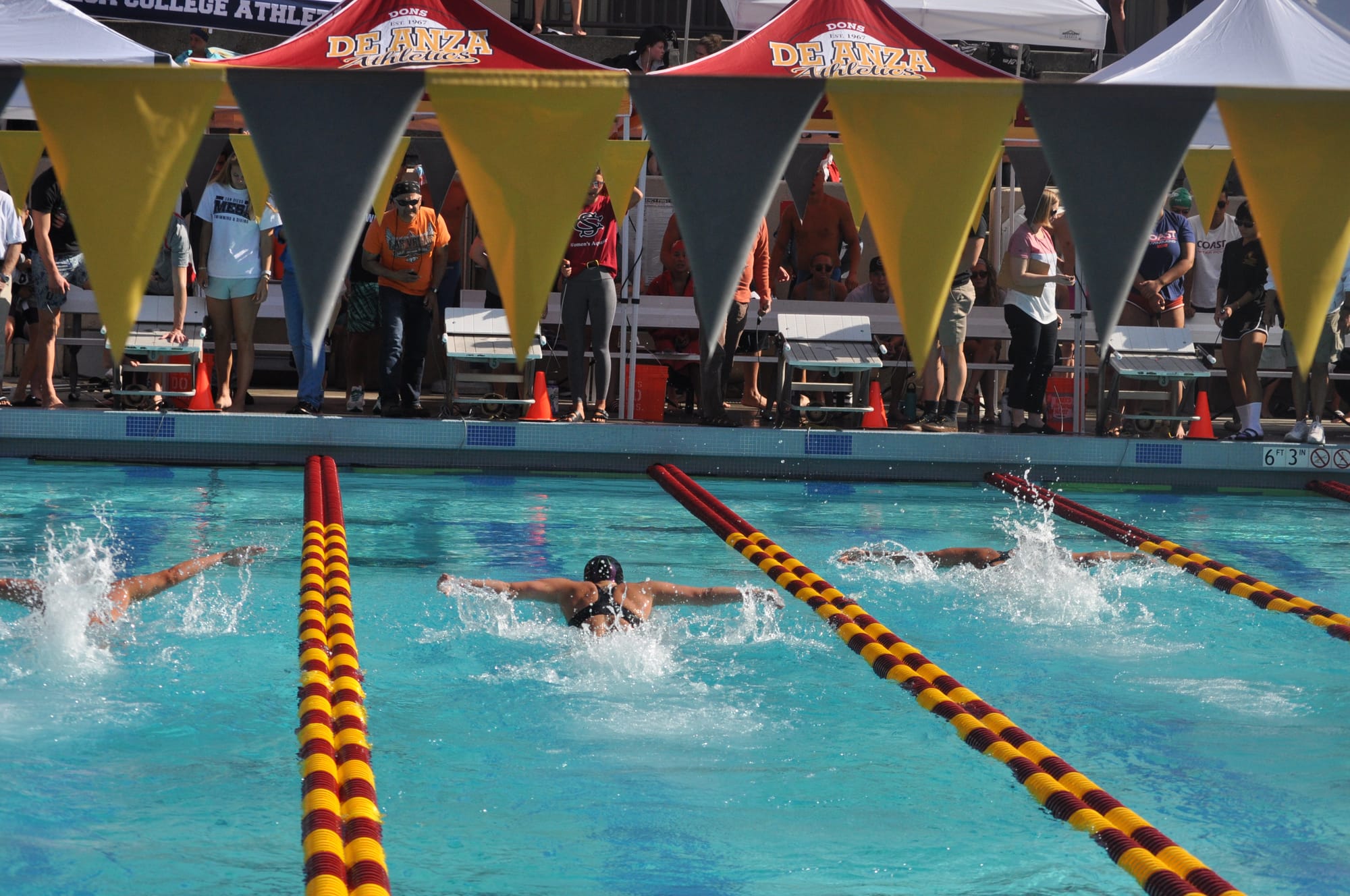 Ashley Davis, center lane, is neck and neck with other swimmers in the 100 Yard Fly. Photo by Peter J. Suter/The Guardsman.